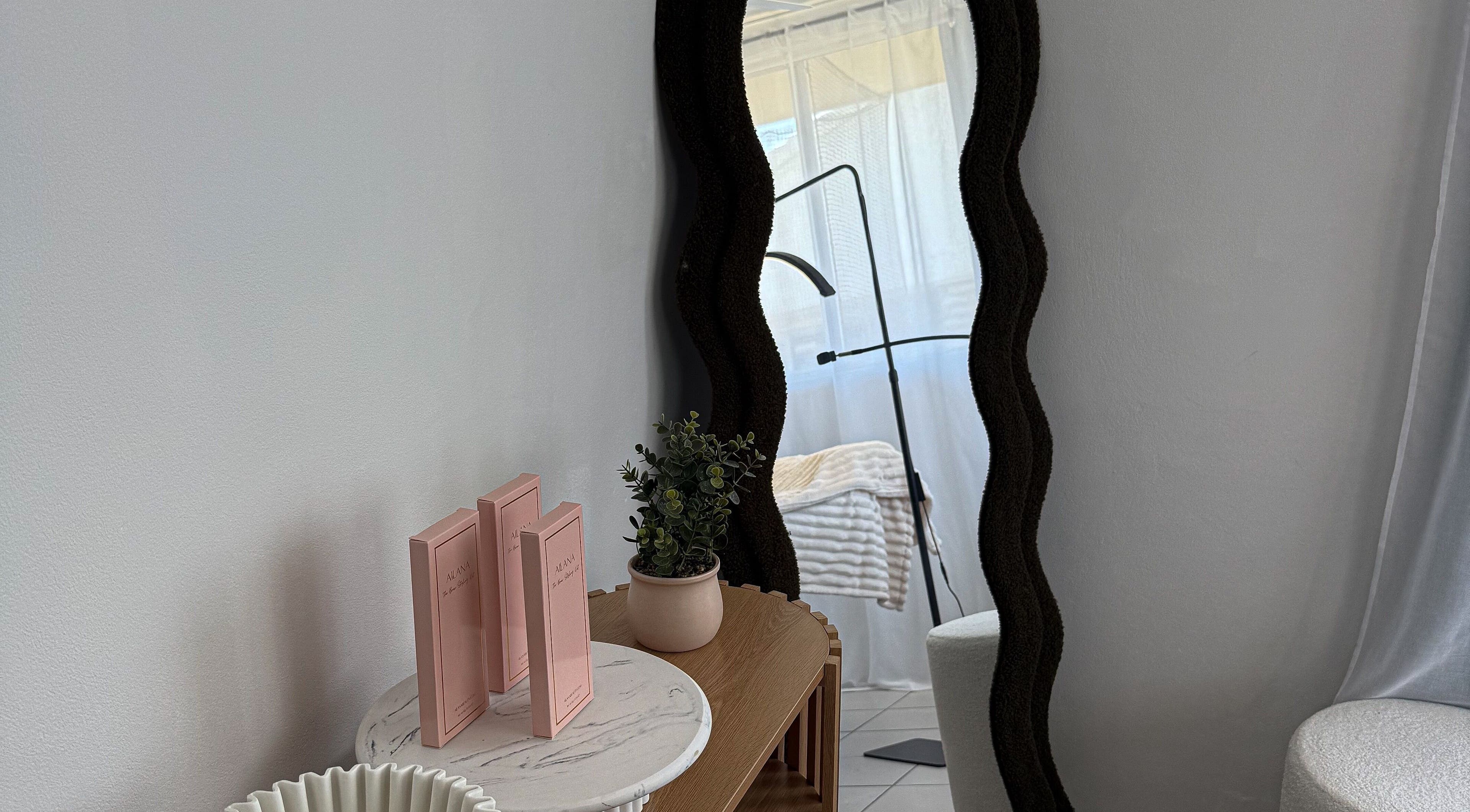 Elegant mirror and decor in Arch Aesthetic Co. at Palm Beach, Queensland, AU enhances the serene atmosphere.