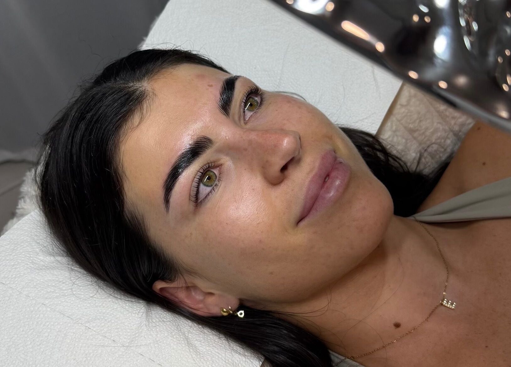Woman enjoys facial treatment at Arch Aesthetic Co. in Palm Beach, Queensland, AU showcasing glowing skin.