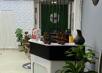 Recepción elegante en Q'Barbaros, Bogotá, Bogotá, CO, con detalles en madera y plantas decorativas.
