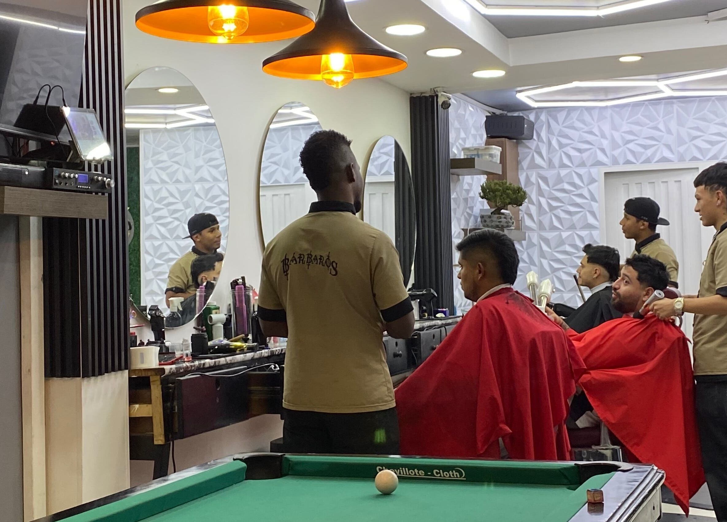 Interior de Q'Barbaros en Bogotá, Bogotá, CO, mostrando estilistas profesionalmente atendiendo a clientes.