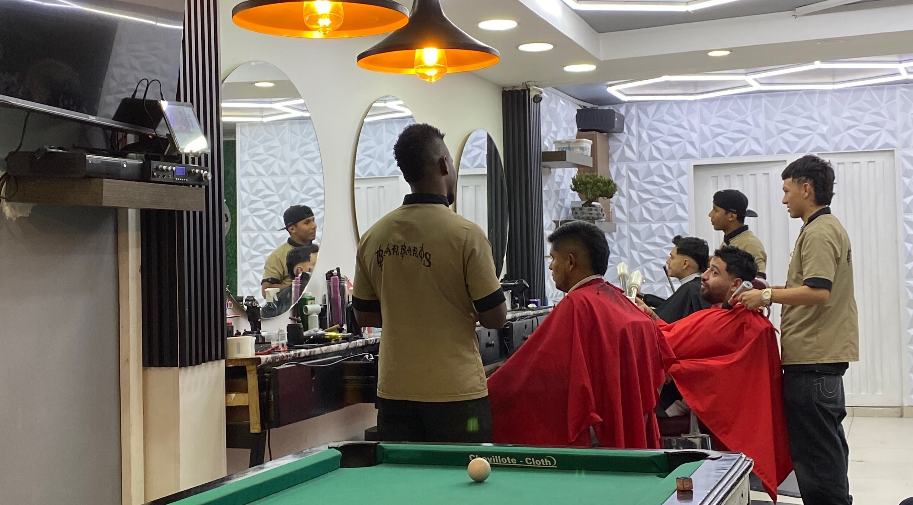 Interior de Q'Barbaros en Bogotá, Bogotá, CO, mostrando estilistas profesionalmente atendiendo a clientes.