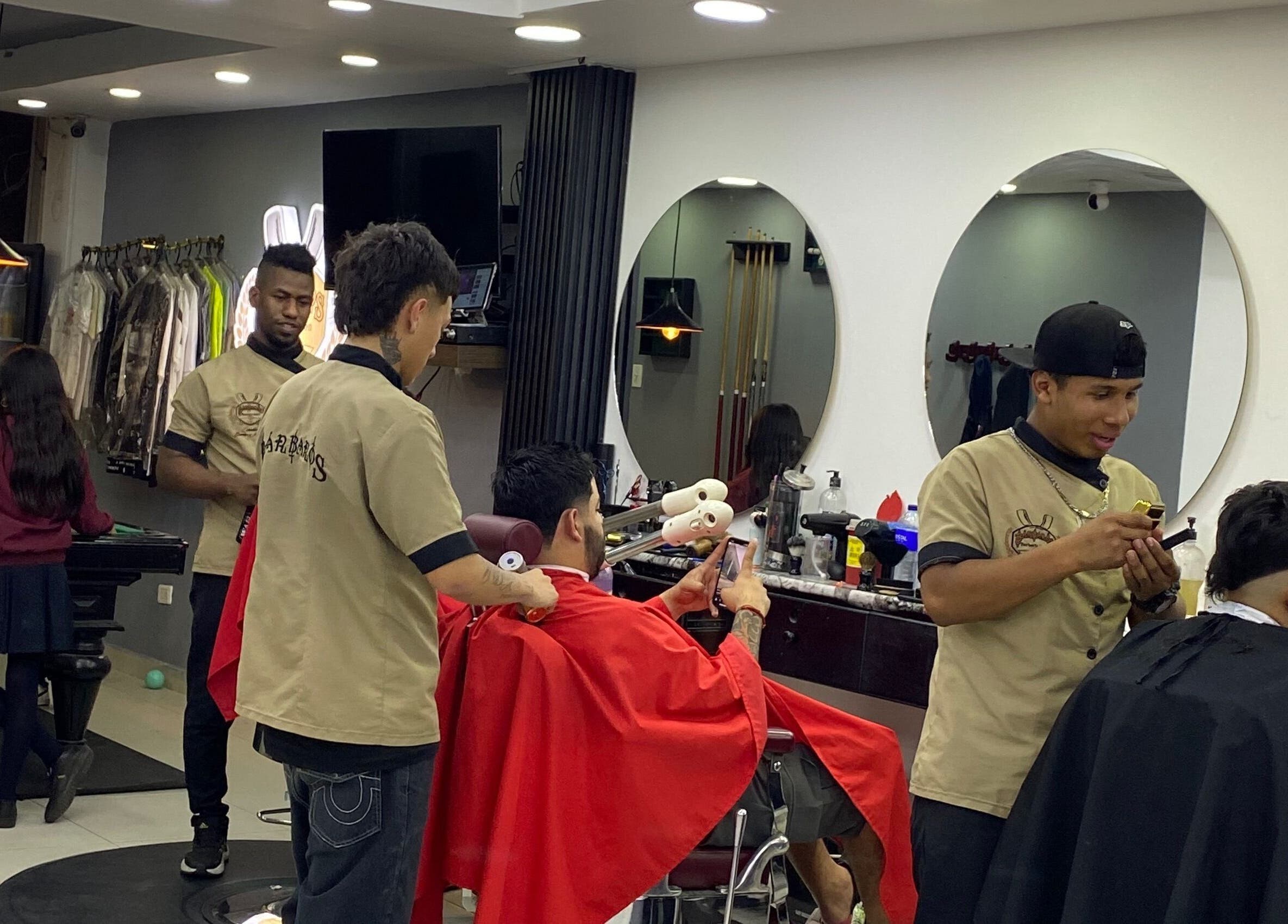 Barberos en Q'Barbaros, Bogotá, Bogotá, CO, atendiendo clientes con cortes modernos y ambiente agradable.