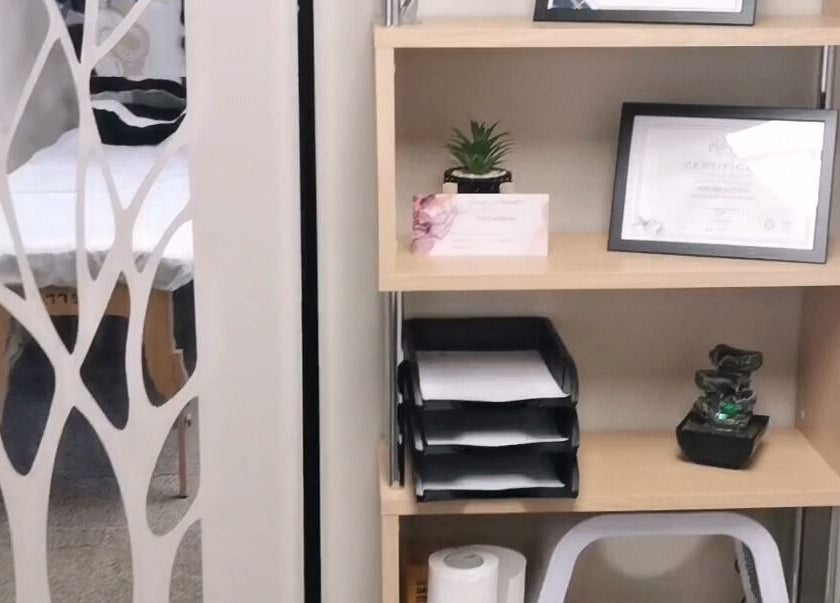 Elegantly arranged wooden shelf at Easy Silhouette, Peterborough, England, GB displaying certificates and decor.