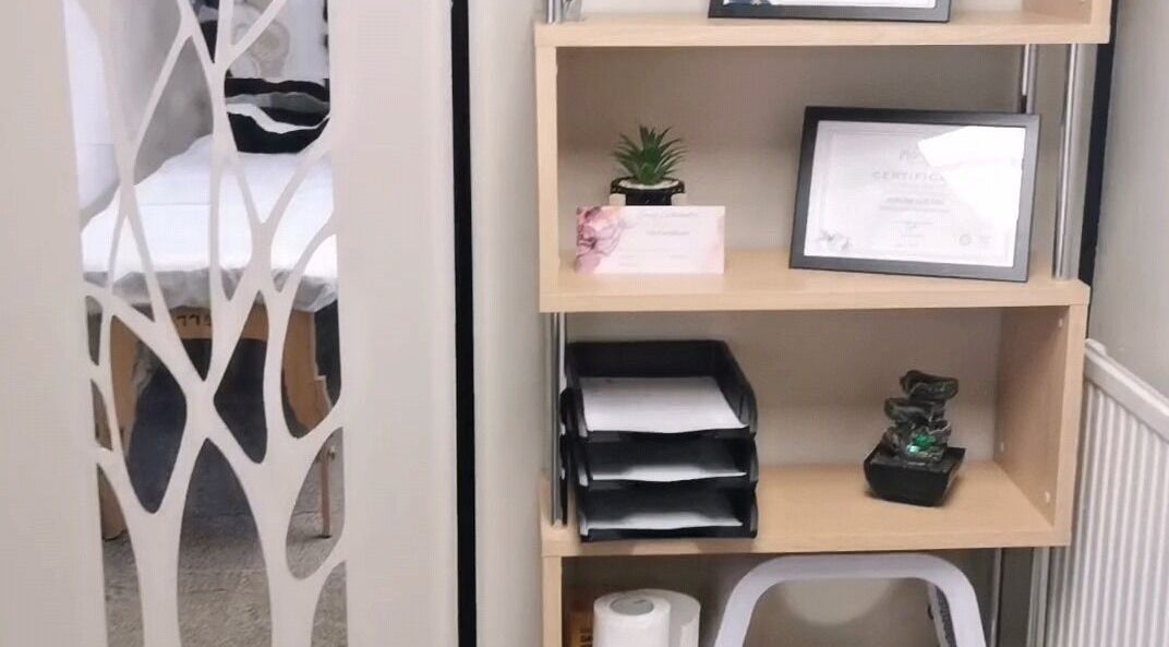 Elegantly arranged wooden shelf at Easy Silhouette, Peterborough, England, GB displaying certificates and decor.