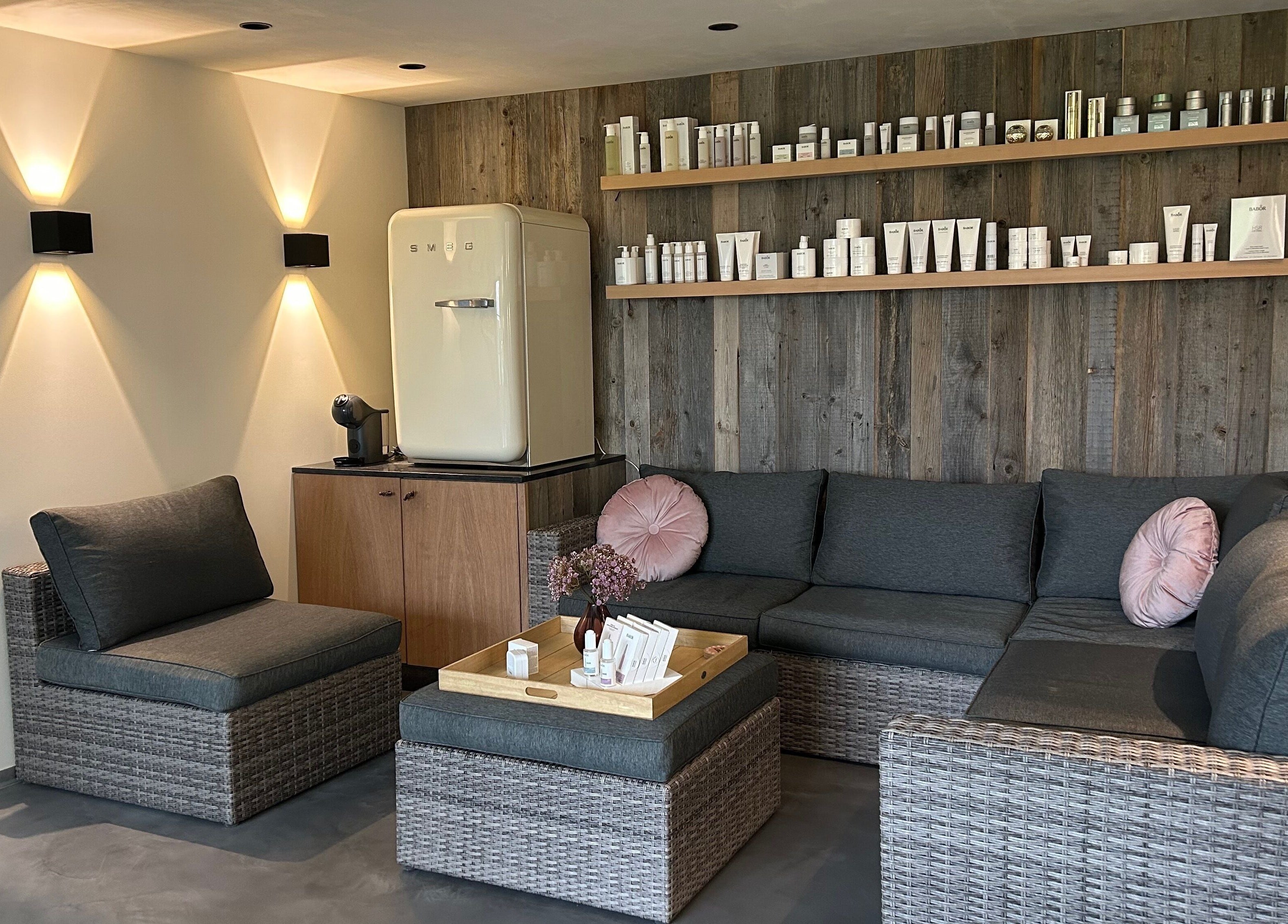 Gezellige loungehoek bij Instituut Belle á Belle, Ingelmunster, Vlaanderen, BE, met grijze zitmeubels en houten wand.