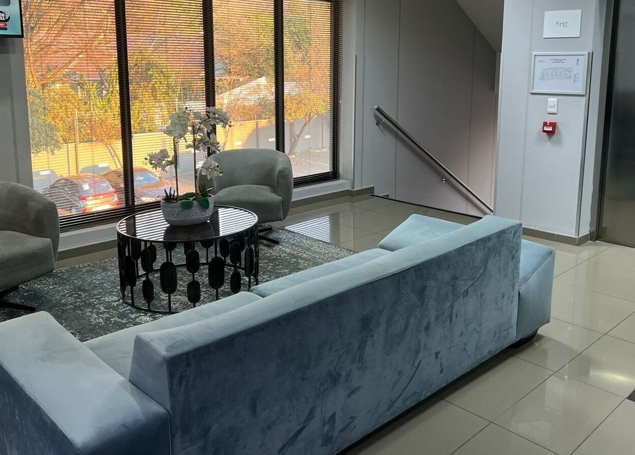 Elegant waiting area at Déjà Vu Aesthetics, Sandton, Gauteng, ZA with plush seating and natural light.