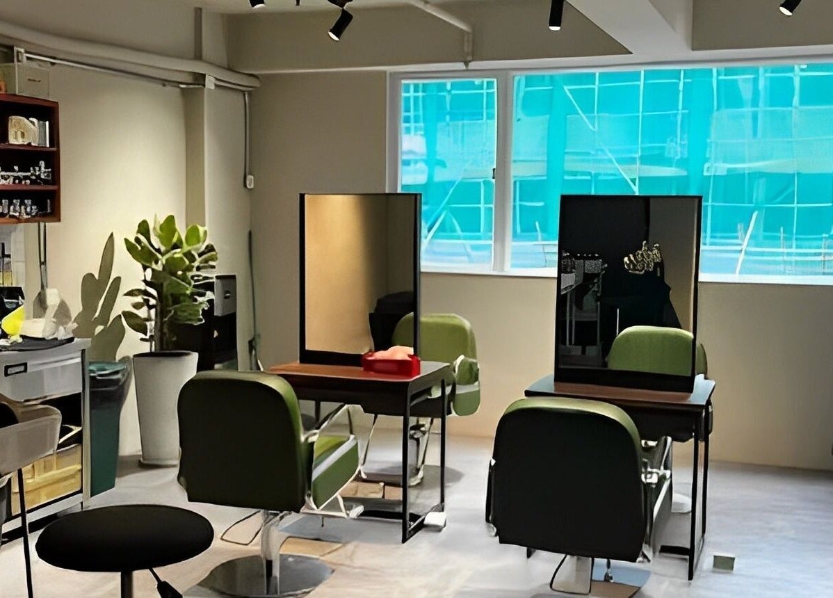Modern interior of PEACH Japanese Hair Salon on Hong Kong Island, HK, showcasing green chairs and mirrors.