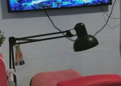 Estación de manicura en Any Uñitas, Managua, Managua, NI, con lámpara y flores decorativas.