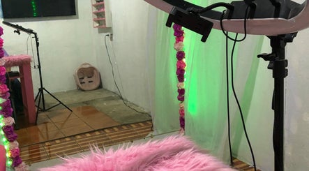 Sala decorada en Any Uñitas, Managua, Managua, NI, con iluminación verde y detalles rosados.