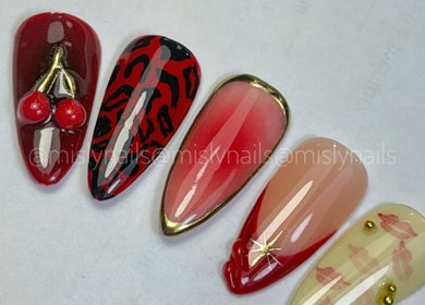 Uñas decoradas en Blomish Studio, Santo Domingo, con diseños artísticos y colores rojos vibrantes.