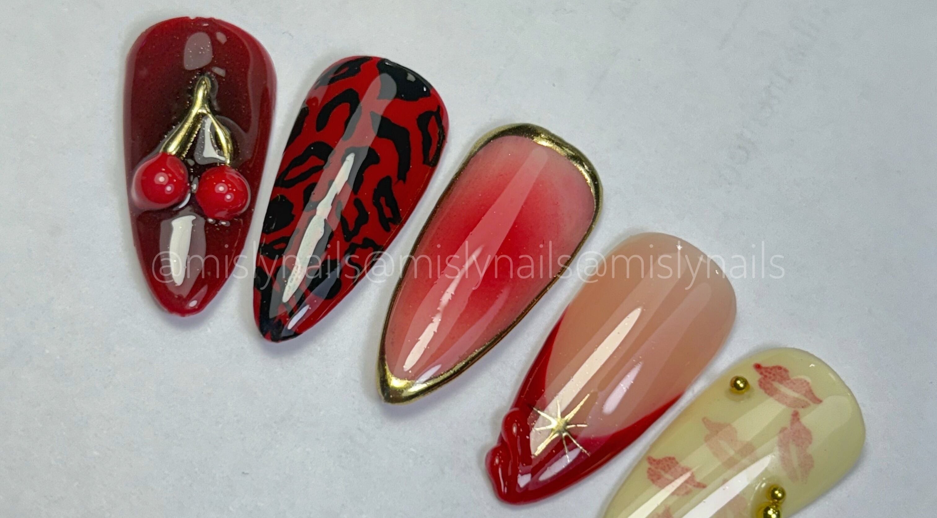 Uñas decoradas en Blomish Studio, Santo Domingo, con diseños artísticos y colores rojos vibrantes.