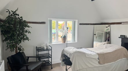 Relaxing treatment room at The Soul Co at Curlita Beauty in Stafford, England, GB, with cozy decor and natural light.