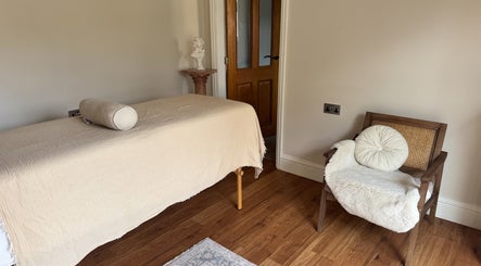 A tranquil room at The Soul Co - (Women Only) - Walsall, featuring a massage table and cozy chair in Walsall, England, GB.