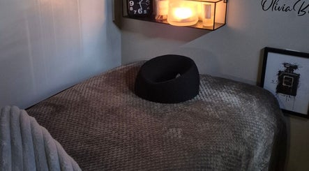 Relaxing treatment room at Oliviabeautè in Eastbourne, England, GB, featuring cozy lighting and soft bed.