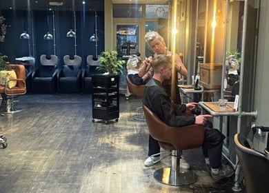 Jo Gulliford Hairstylist at work in a sleek salon in Brighton And Hove, GB, offering expert haircuts.