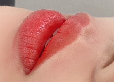 Close-up of vibrant, glossy red lips at Luna Beauty Melbourne, located in Melbourne, Victoria, AU.