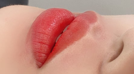 Close-up of vibrant, glossy red lips at Luna Beauty Melbourne, located in Melbourne, Victoria, AU.