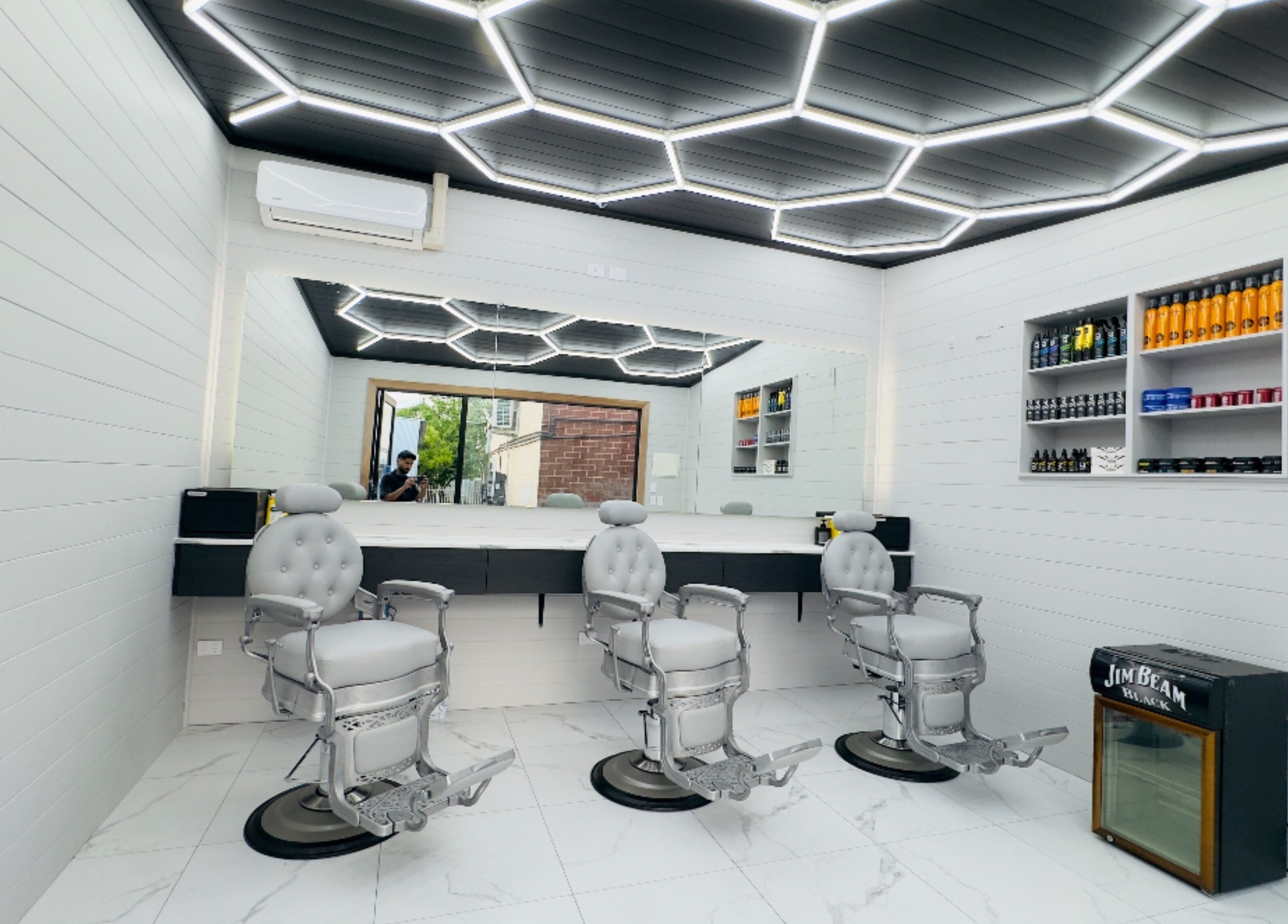 Modern barber chairs in Raz Fades, Croydon, South Australia, AU with stylish lighting and product display.