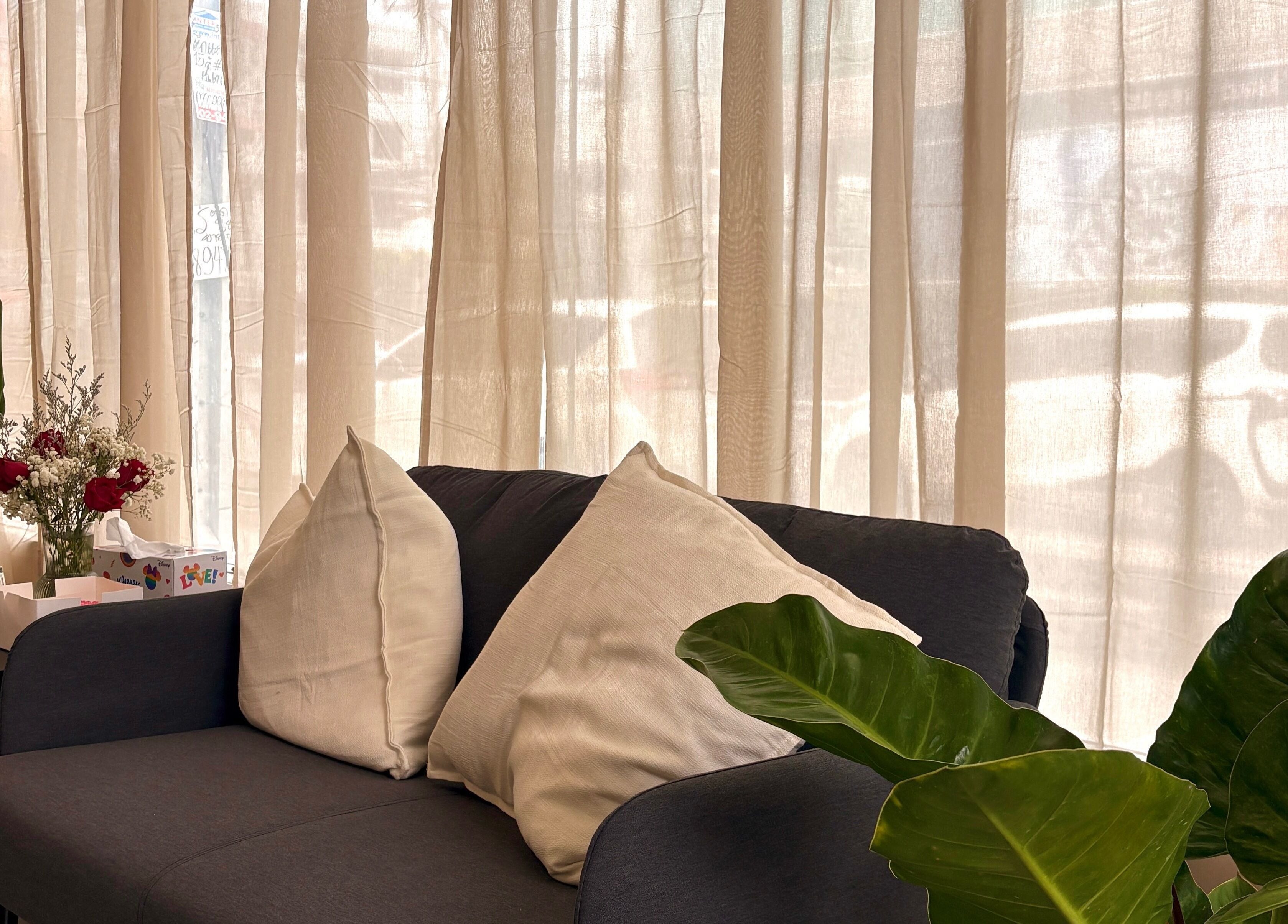 Elegant seating area at YIN Nails and Lashes, Krung Thep Maha Nakhon. Plush sofa with cushions and tasteful decor.