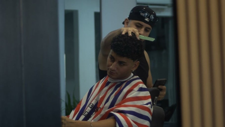 A barber expertly styles hair at Alberto's Barber and Wellness Hub in Gzira, MT, enhancing client experience.