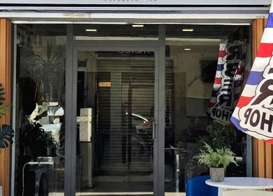 Entrance of Alberto's Barber and Wellness Hub in Gzira, MT, featuring welcoming decor and barber flags.