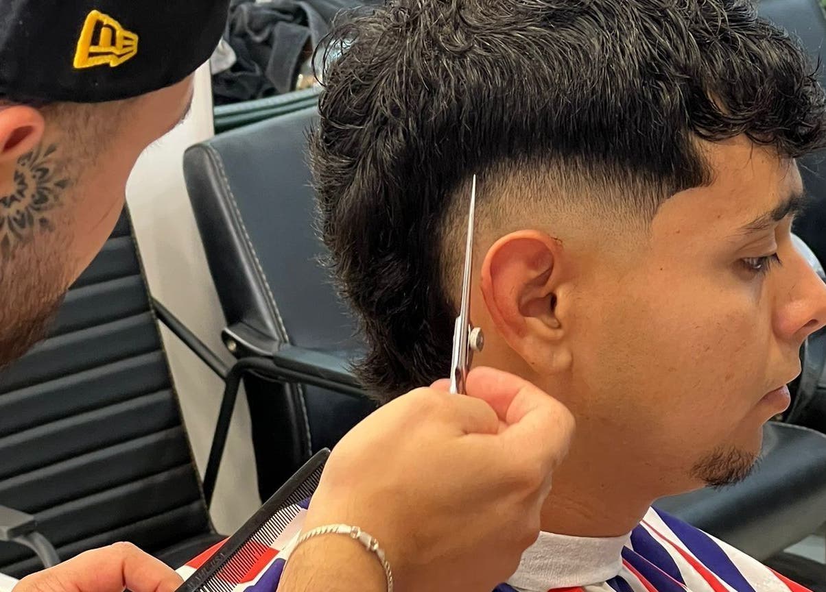 Barber crafting a sharp haircut at Alberto's in Gzira, MT, showcasing expert styling.