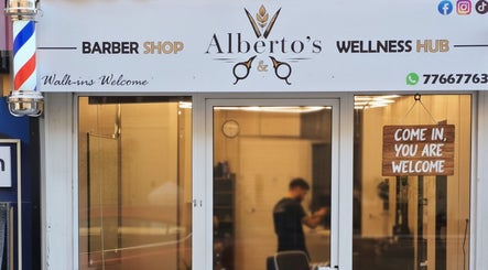 Entrance to Alberto's Barber Shop in San Ġiljan, MT showcasing inviting sign and decor.