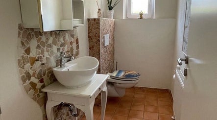 Elegant restroom at The Wax Room in Weiden In Der Oberpfalz, Bayern, DE with mosaic tiles and a modern basin.