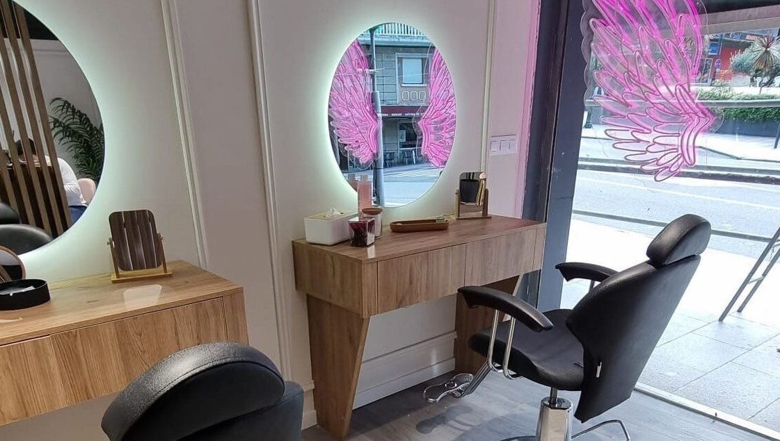 Interior moderno en Clinic Nails, Vigo, ES, con espejo iluminado y detalles decorativos rosas.
