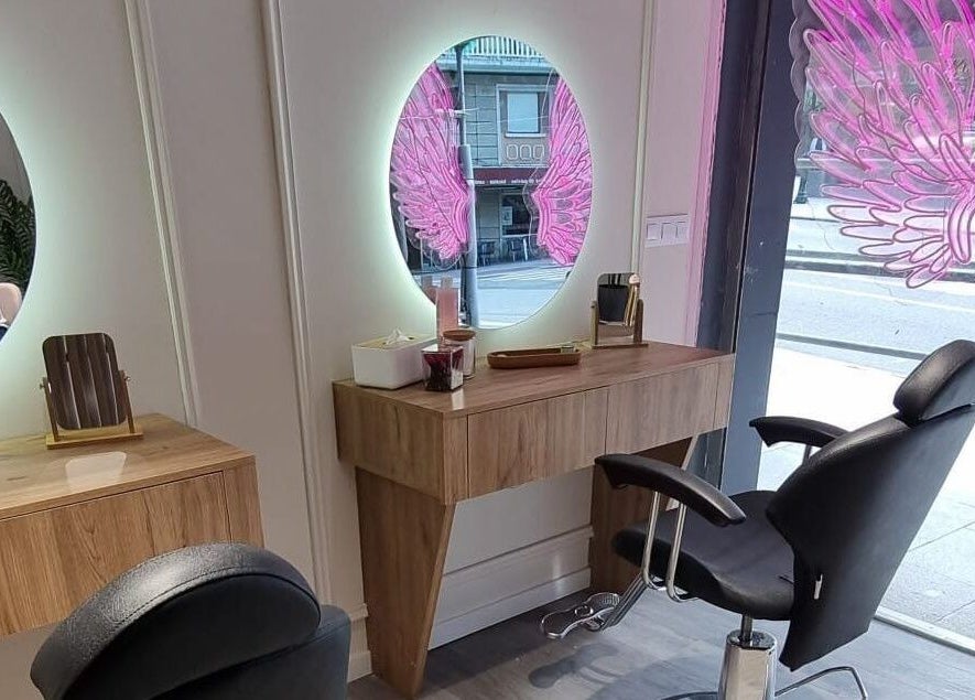 Interior moderno en Clinic Nails, Vigo, ES, con espejo iluminado y detalles decorativos rosas.