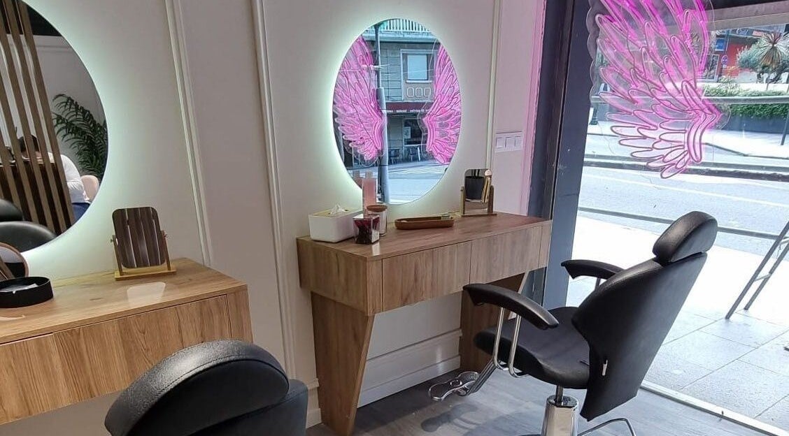 Interior moderno en Clinic Nails, Vigo, ES, con espejo iluminado y detalles decorativos rosas.