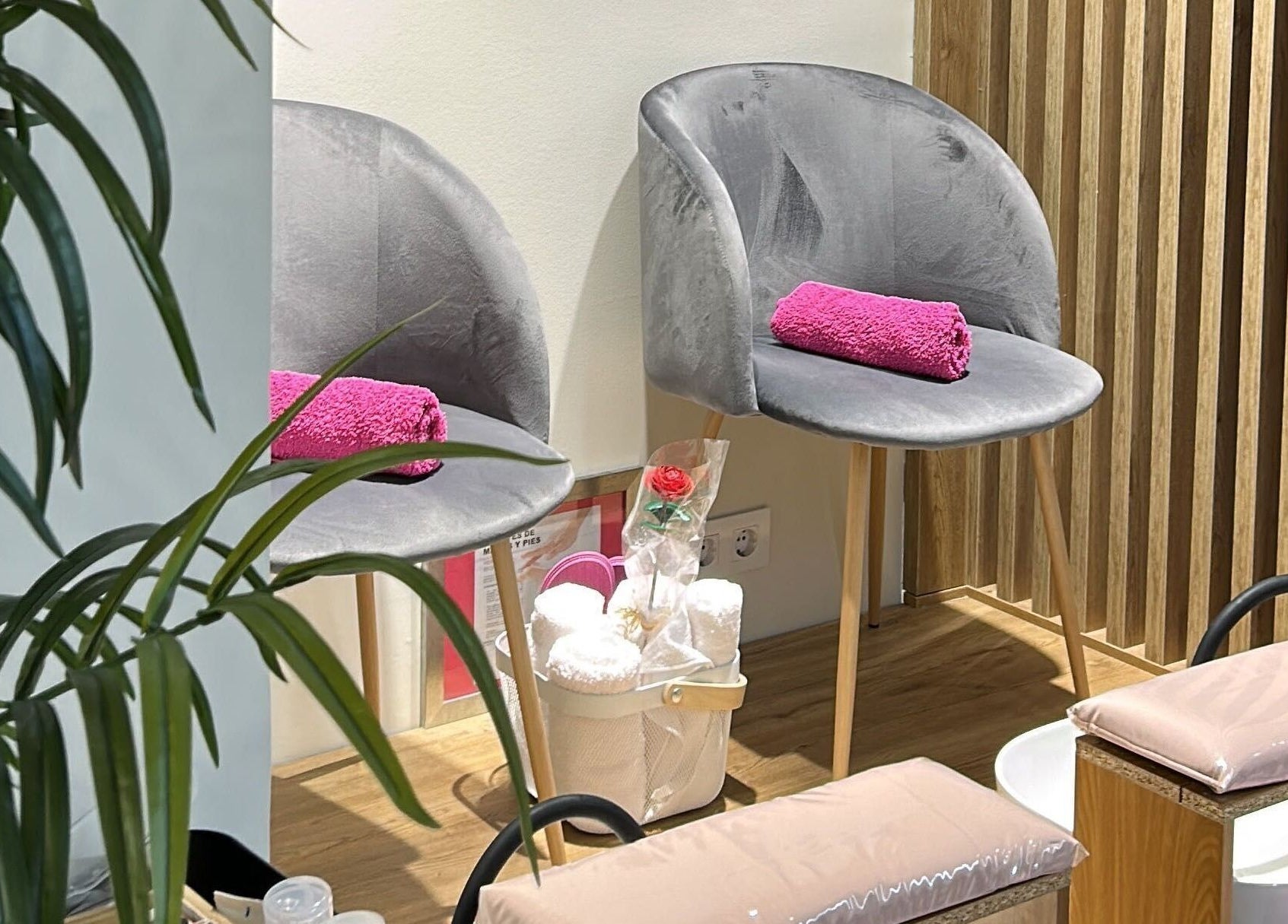 Sillas grises con toallas rosas en Clinic Nails, un espacio acogedor en Vigo, ES para relajación y bienestar.