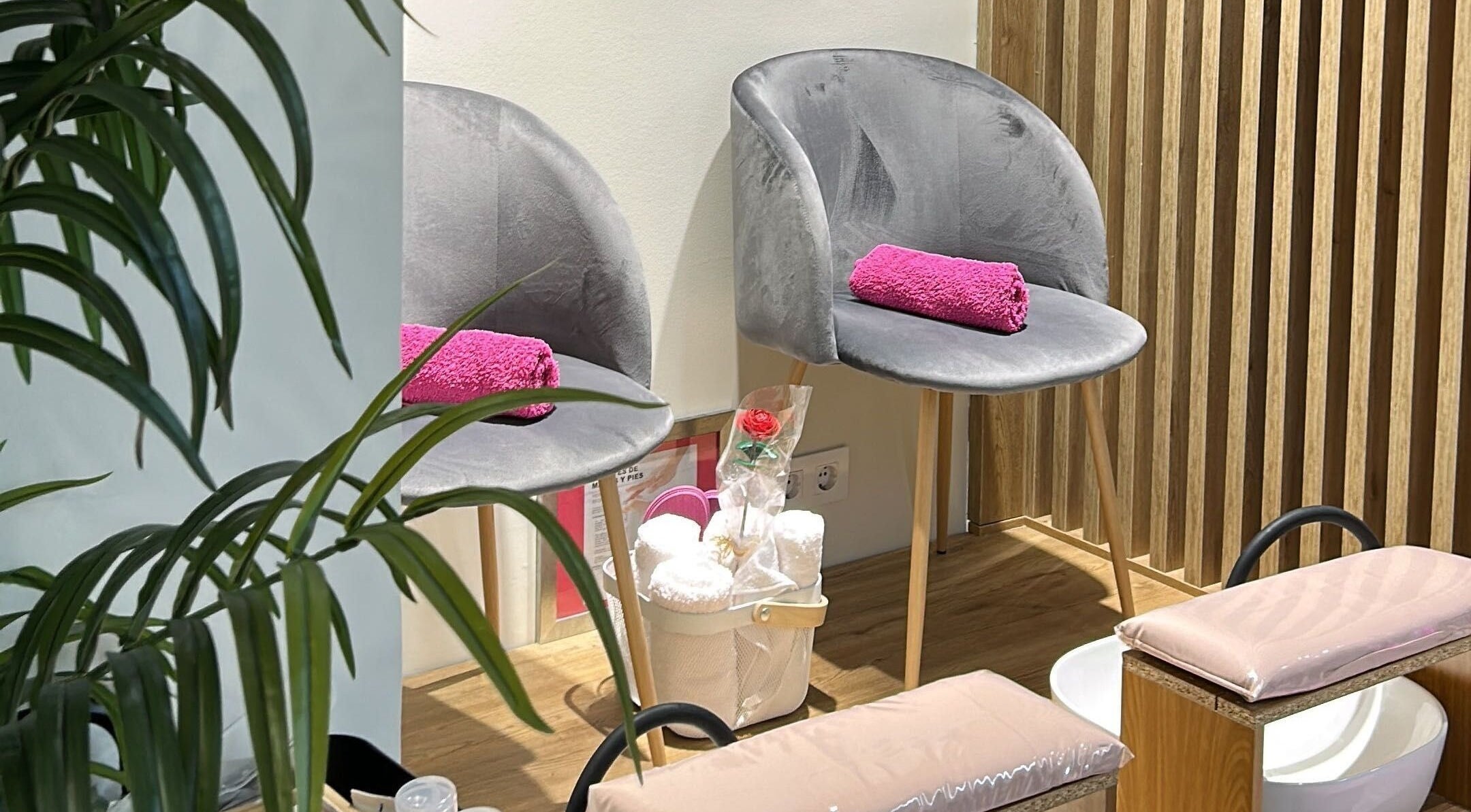 Sillas grises con toallas rosas en Clinic Nails, un espacio acogedor en Vigo, ES para relajación y bienestar.