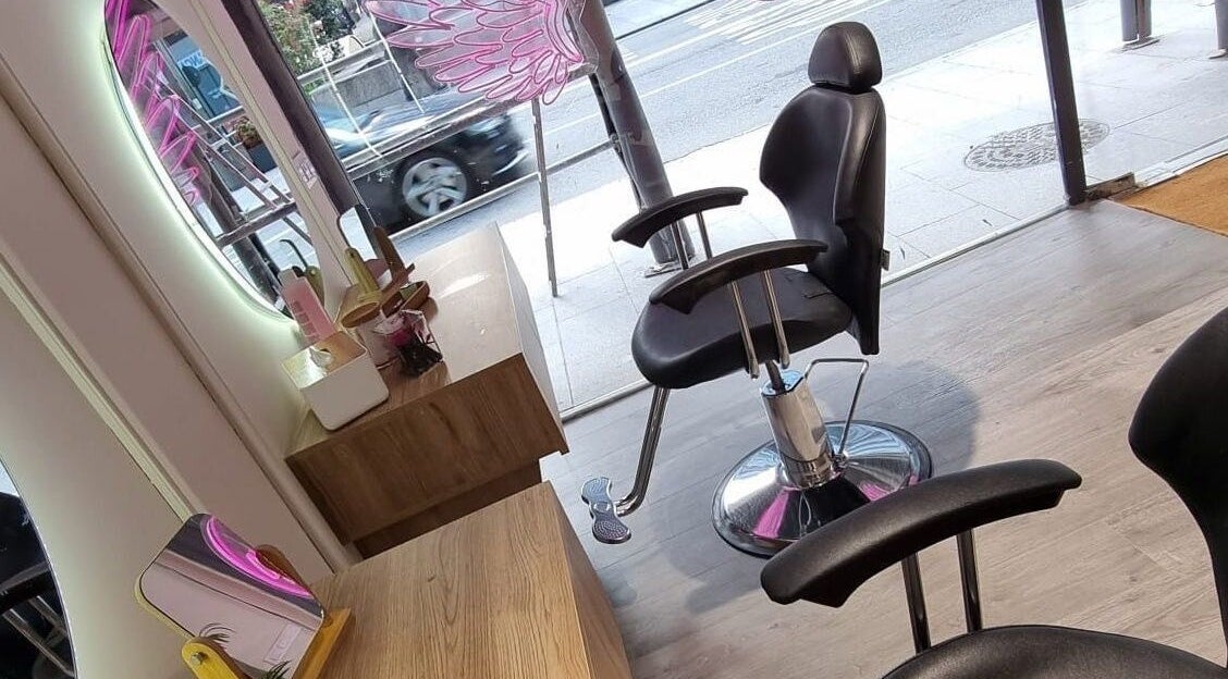 Silla de salón en Clinic Nails, Vigo, ES, junto a espejo iluminado y decoración moderna.