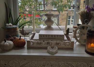 Charming decor at Wild Aura Denny, Denny, Scotland, GB, featuring candles and aesthetic accents by a window.