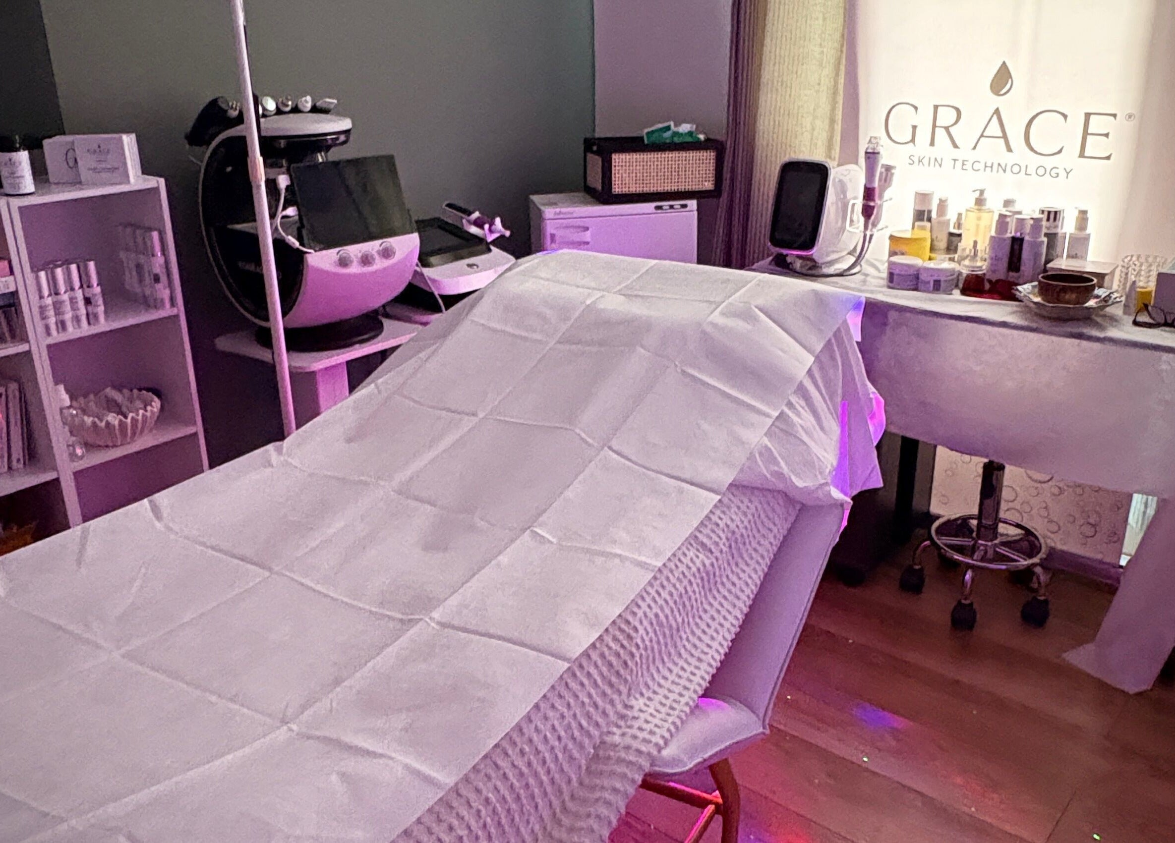 Spa room at GRACE SKIN TECHNOLOGY, Cranleigh, England, GB, showcasing a relaxing treatment bed and skincare products.