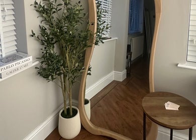 Elegant corner at El Emery Makeup & Beauty, ST21 6JU, England, with wavy mirror and plants.
