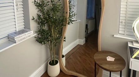 Elegant corner at El Emery Makeup & Beauty, ST21 6JU, England, with wavy mirror and plants.