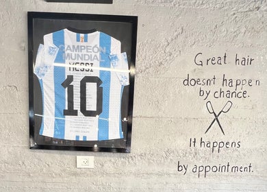 Framed jersey and inspiring quote on a wall at Abu Al Naser Salon in Nablus, IL.