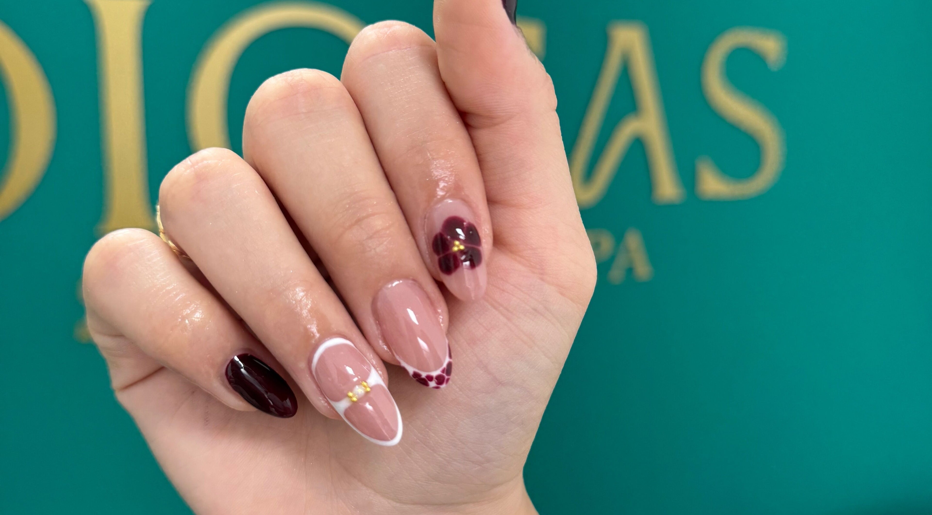 Uñas decoradas con diseño floral y tonos burdeos en Diosas Studio Spa, Bucaramanga, Santander, CO.