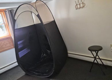 Spray tan setup at Star Child Esthetics LLC, Midland, Michigan, US, featuring a tent and stool.