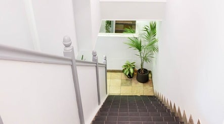 Elegant stairway at Newelle Beauty, London, England, GB featuring potted plants and bright walls.