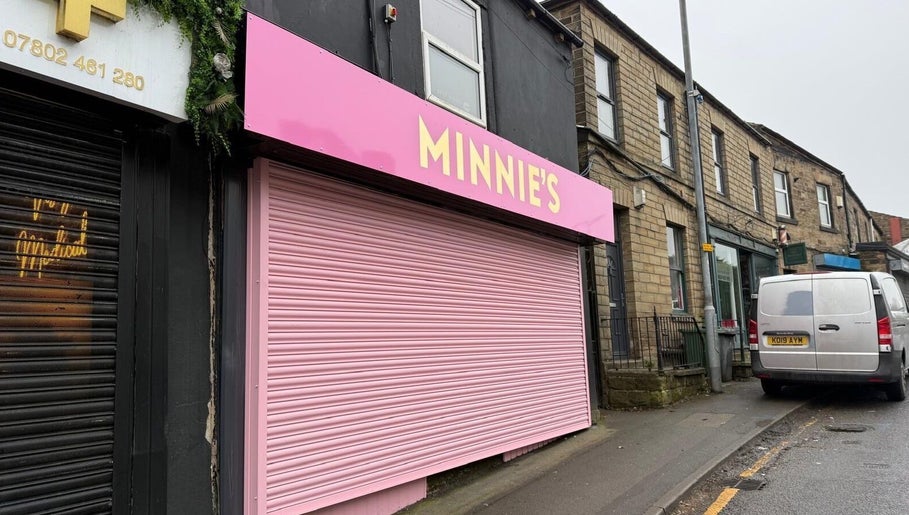 Pink storefront of Minnie's in Birstall, England, GB, showcasing its vibrant exterior.
