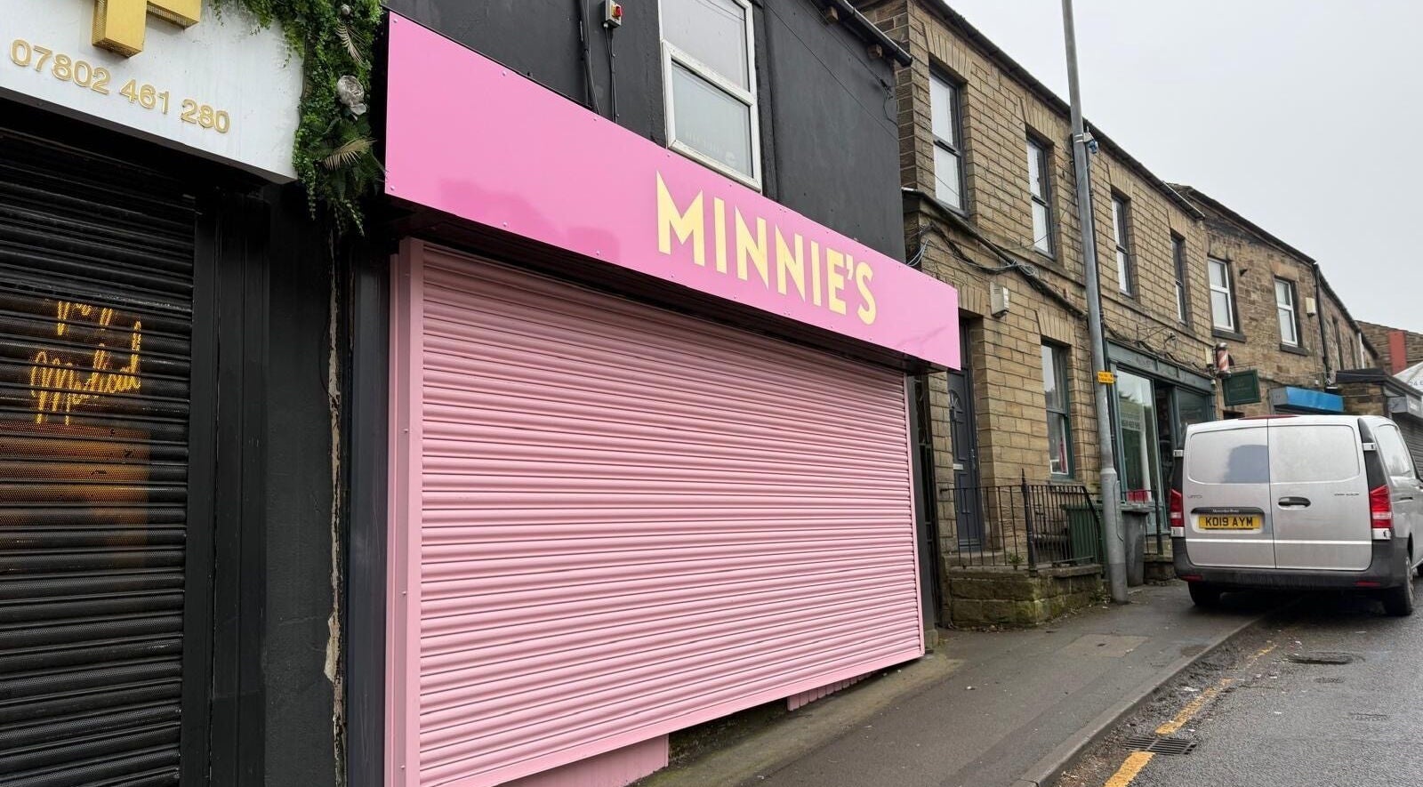 Pink storefront of Minnie's in Birstall, England, GB, showcasing its vibrant exterior.