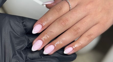 A hand with elegant French-tipped nails at Bydeedeelayy, Horsmonden, England, GB.