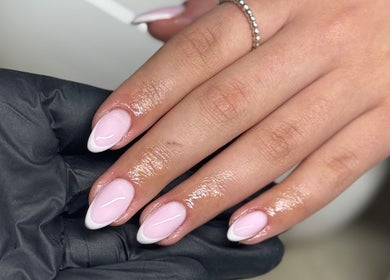 Elegant French manicure at Bydeedeelayy in Horsmonden, England, GB showing glossy pink and white nails.
