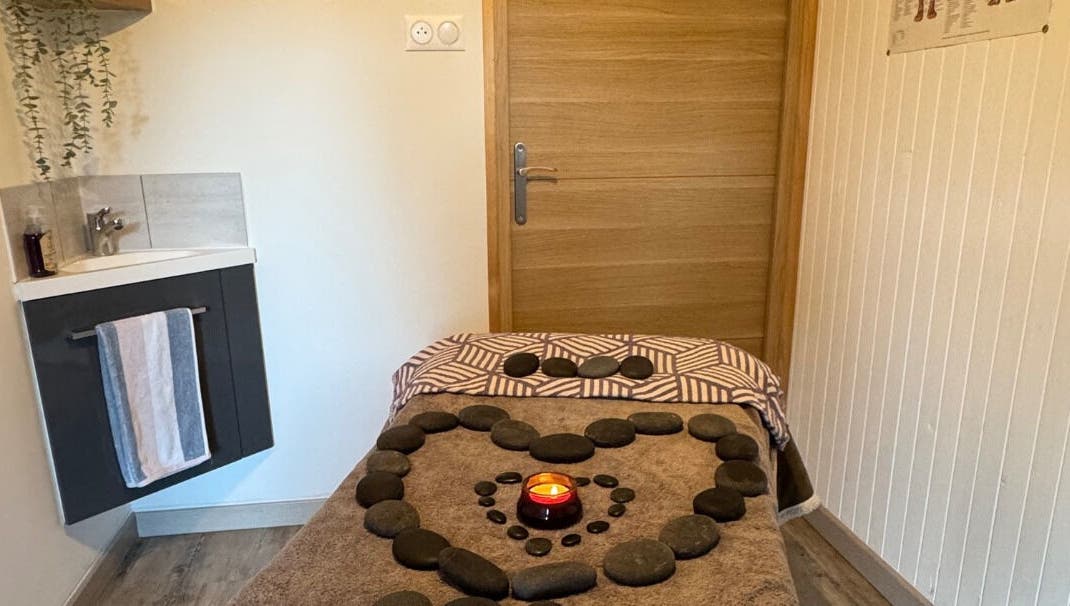 Relaxing massage table at Simple Touch in Saint-jean-d'aulps, Auvergne-rhône-alpes, FR with stones and a candle.