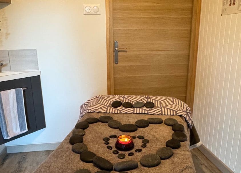 Relaxing massage table at Simple Touch in Saint-jean-d'aulps, Auvergne-rhône-alpes, FR with stones and a candle.