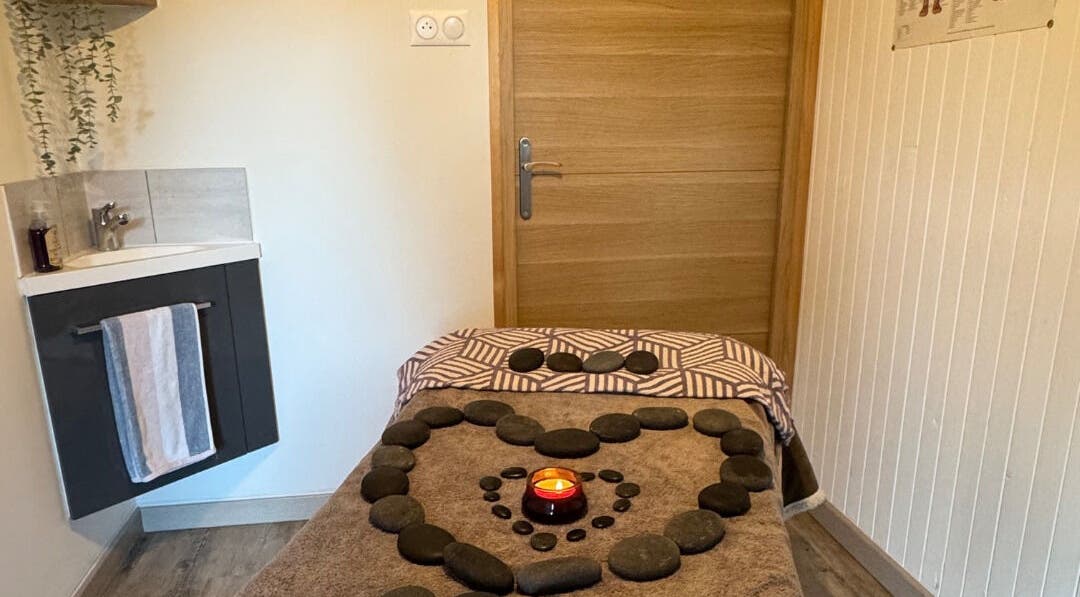 Relaxing massage table at Simple Touch in Saint-jean-d'aulps, Auvergne-rhône-alpes, FR with stones and a candle.