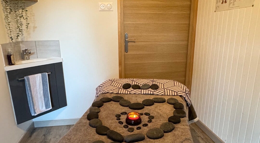Relaxing massage table at Simple Touch in Saint-jean-d'aulps, Auvergne-rhône-alpes, FR with stones and a candle.
